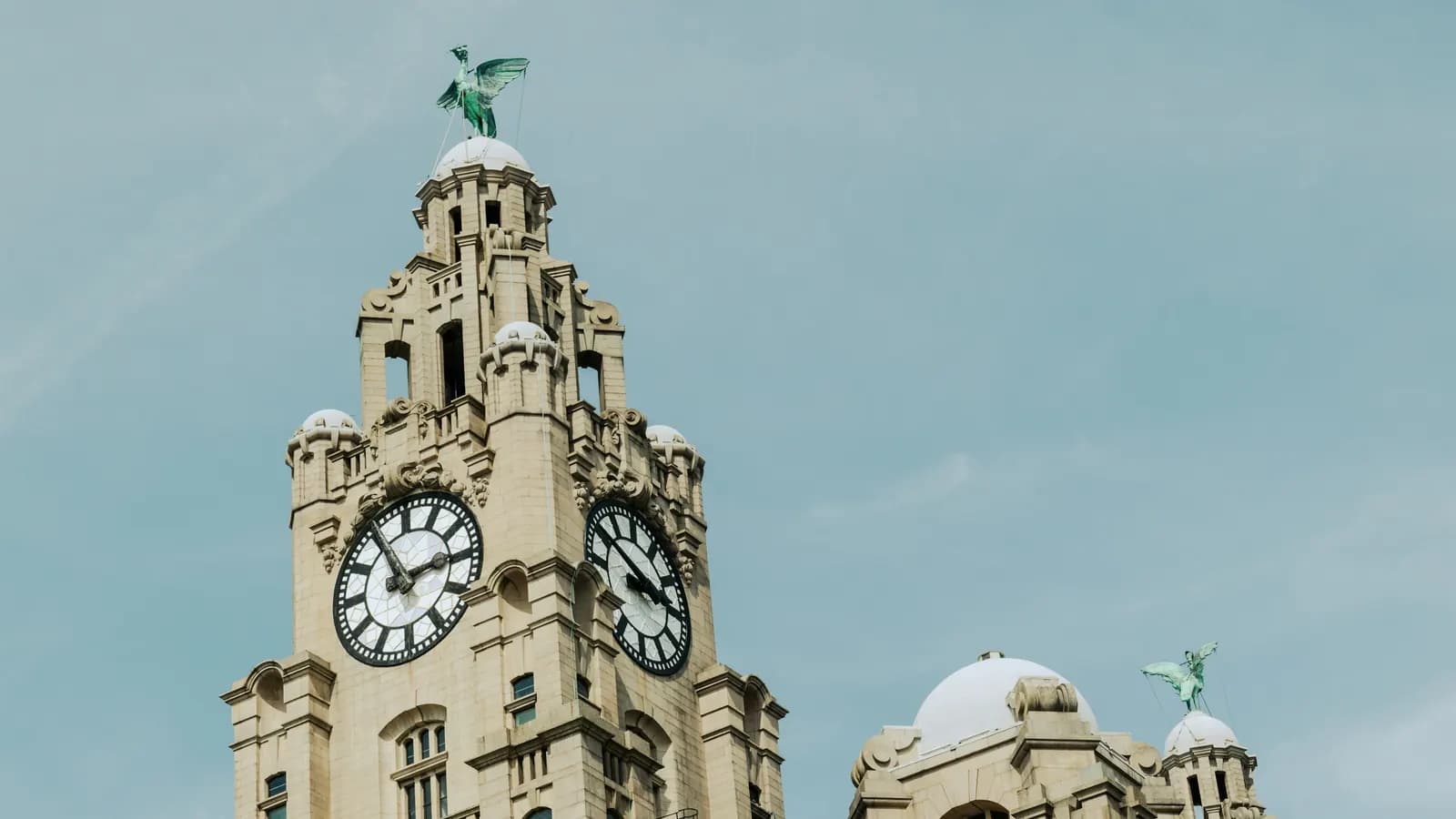 The clock tower of the Royal Liver Building in Liverpool against a pale sky