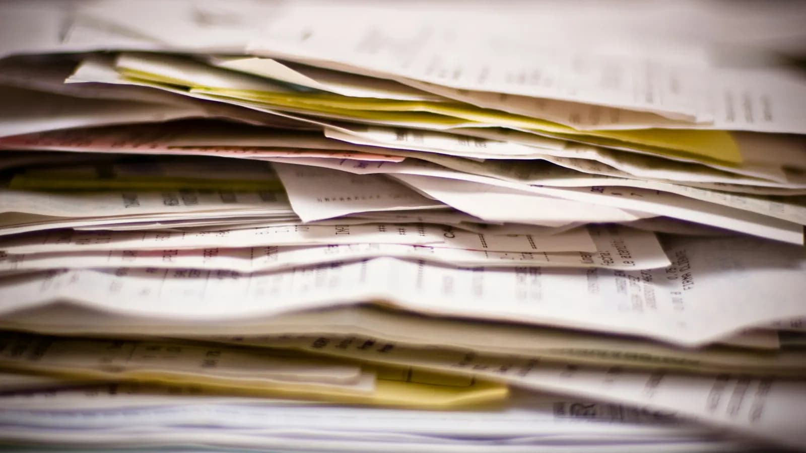 A thick, untidy stack of invoices and paperwork