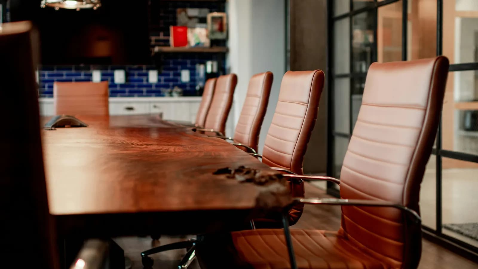 Leather chairs around a long wooden boardroom table